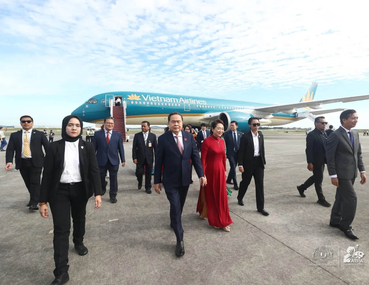 VIP delegation on airport tarmac beside Vietnam Airlines aircraft for AIPA event