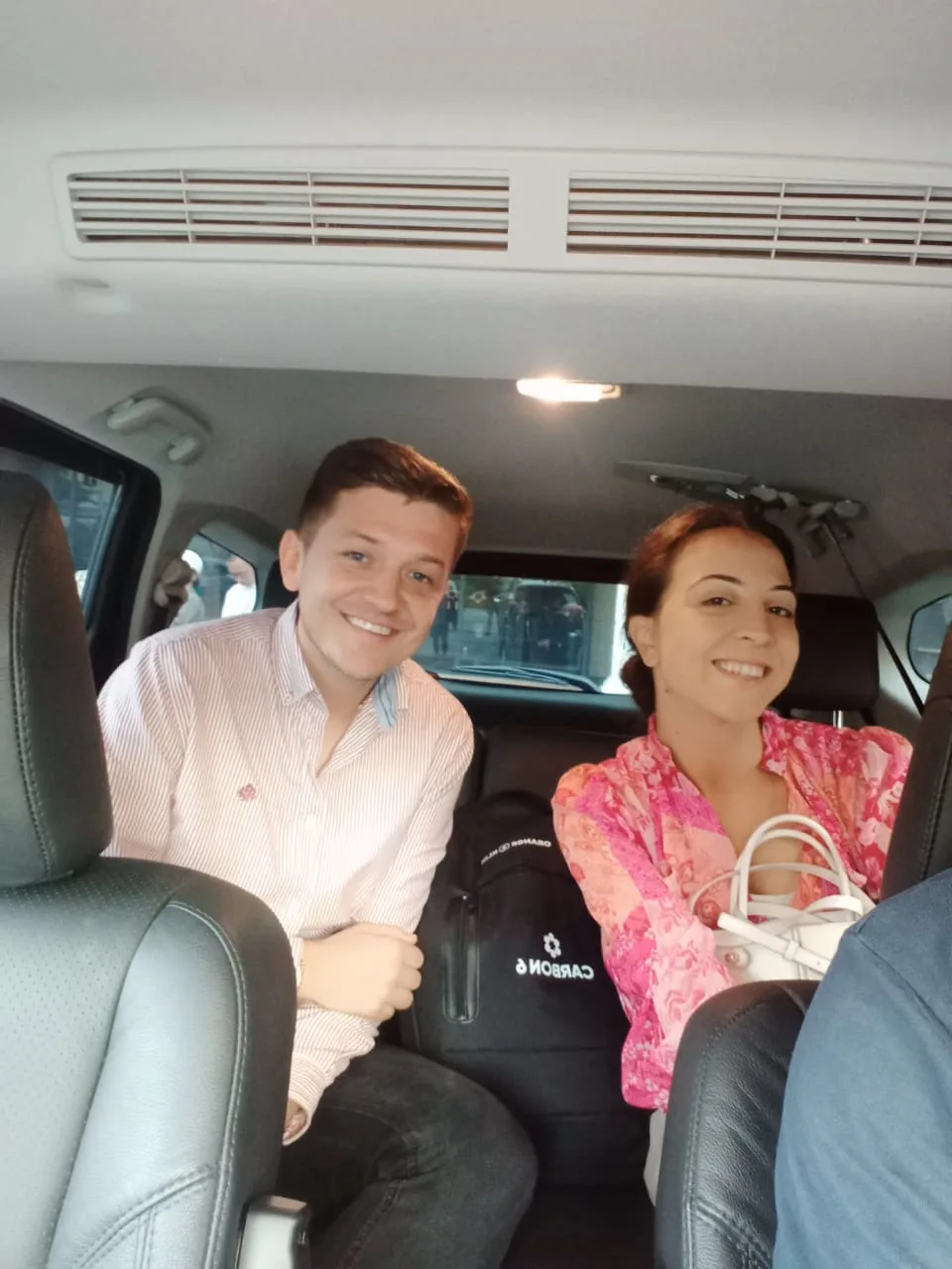 Smiling couple in van enjoying group transfer