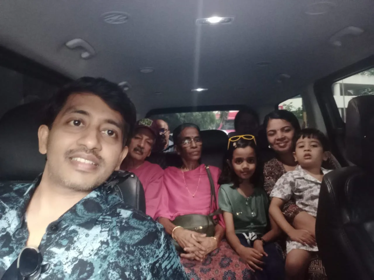 Family of four taking fun selfie in van