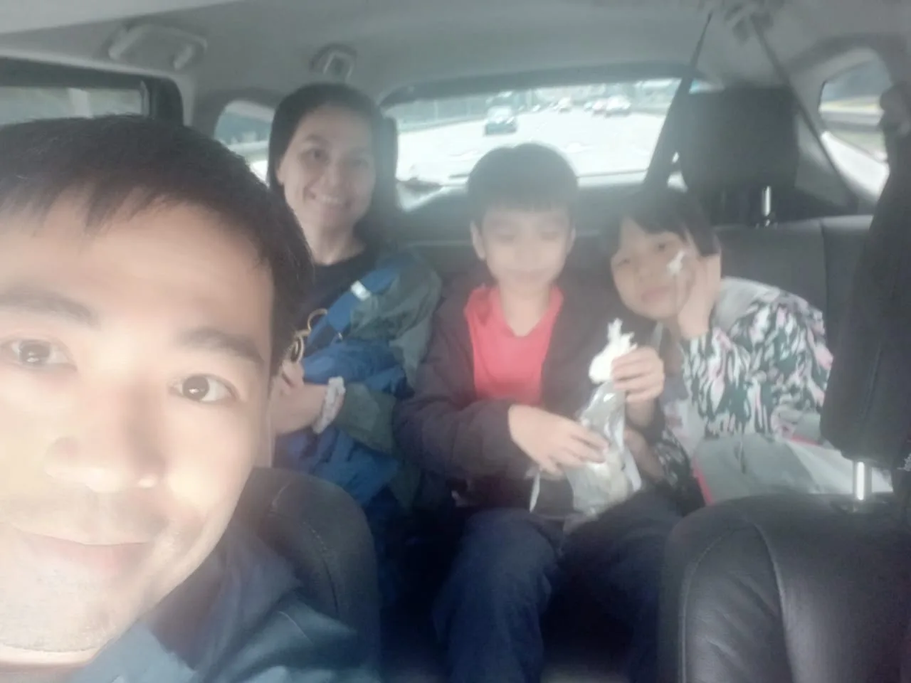 Family with kids enjoying snacks during van ride