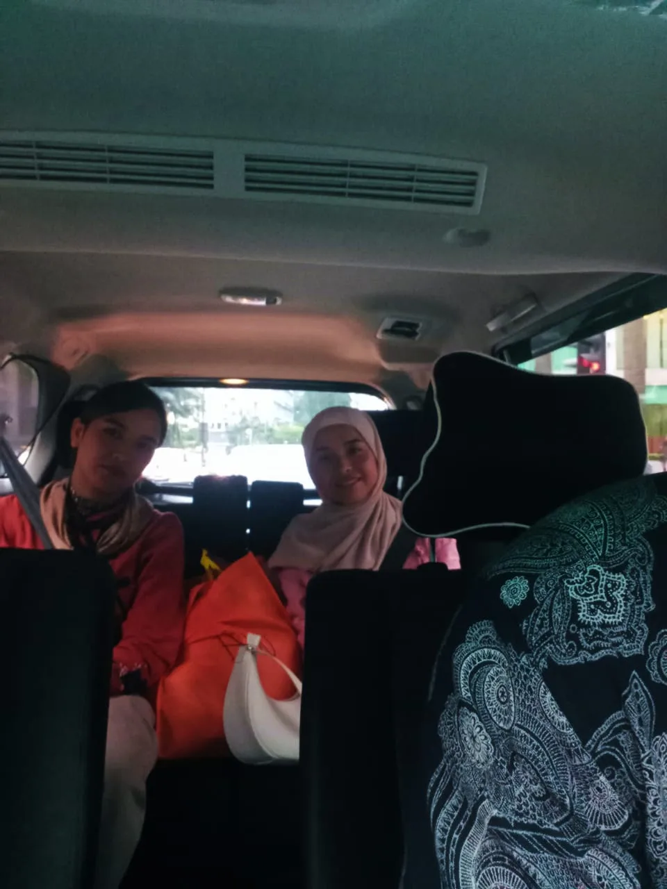 Two friends smiling in van during comfortable city transfer