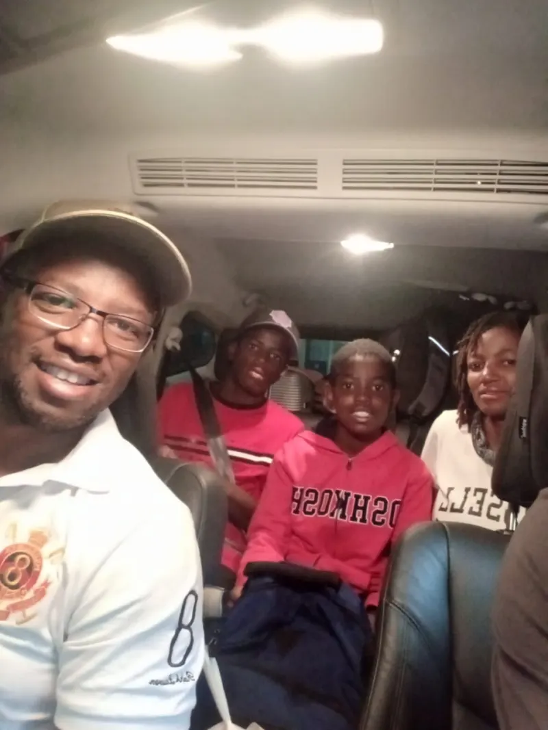 Group of friends taking selfie inside vehicle during road trip