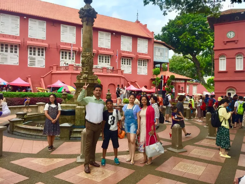 Family at Dutch Square Stadthuys with iconic red buildings in Melaka