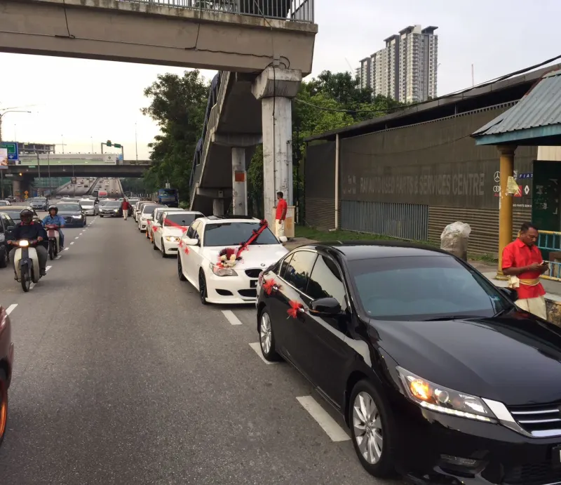 Two white BMW wedding cars decorated with red ribbons